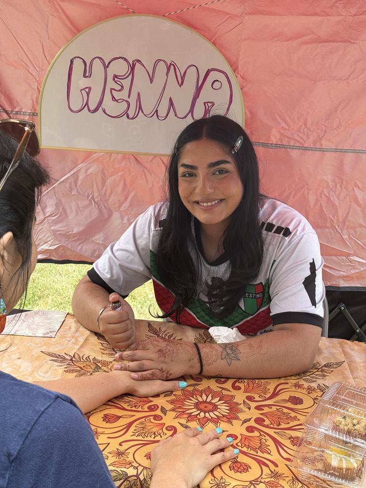 Henna artist at the Community Bazaar, June 2026